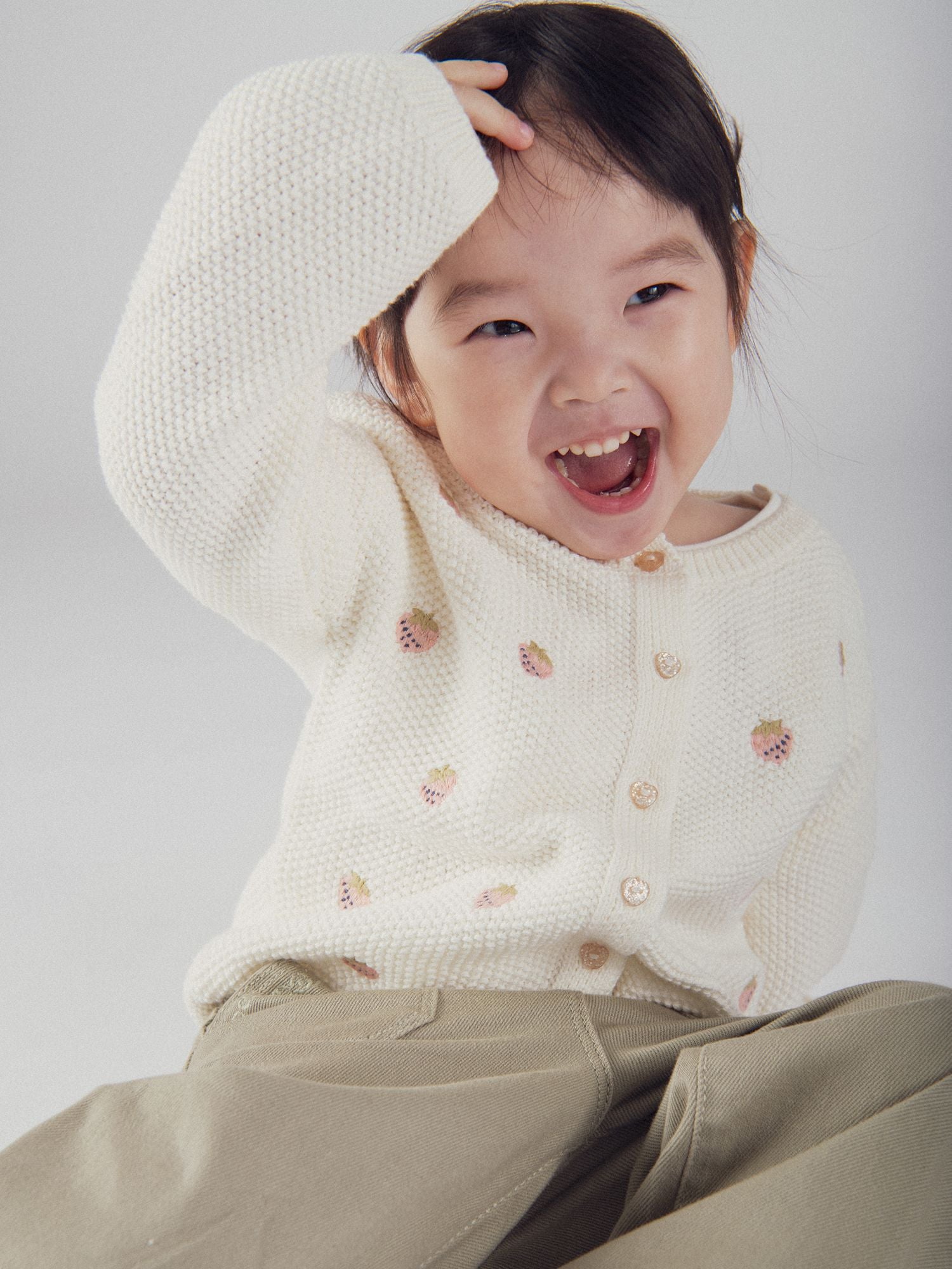 Cardigan en tricot écru avec broderie fraise pour bébé fille